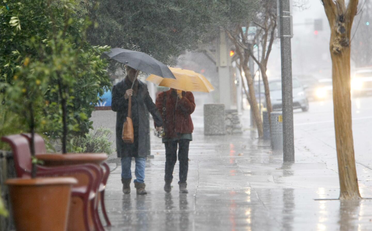 Two people head into Dish restaurant during a downpour on the 700 block of Foothill Blvd., in La Cañada Flintridge on Friday, Jan. 20, 2017. Rain was expected to continue through the weekend.