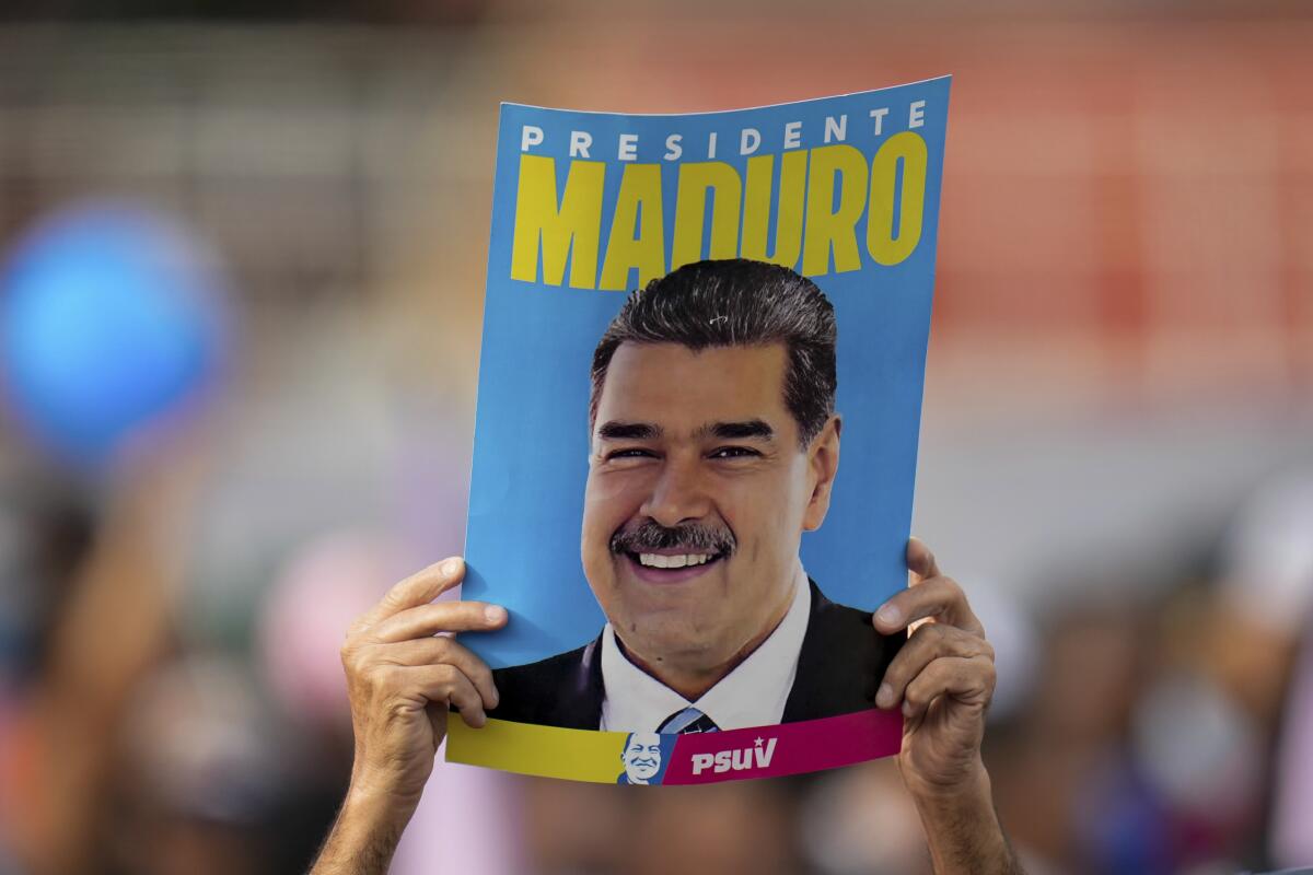 Un seguidor muestra un cartel del presidente, Nicolás Maduro, durante su mitin de cierre de campaña en Caracas