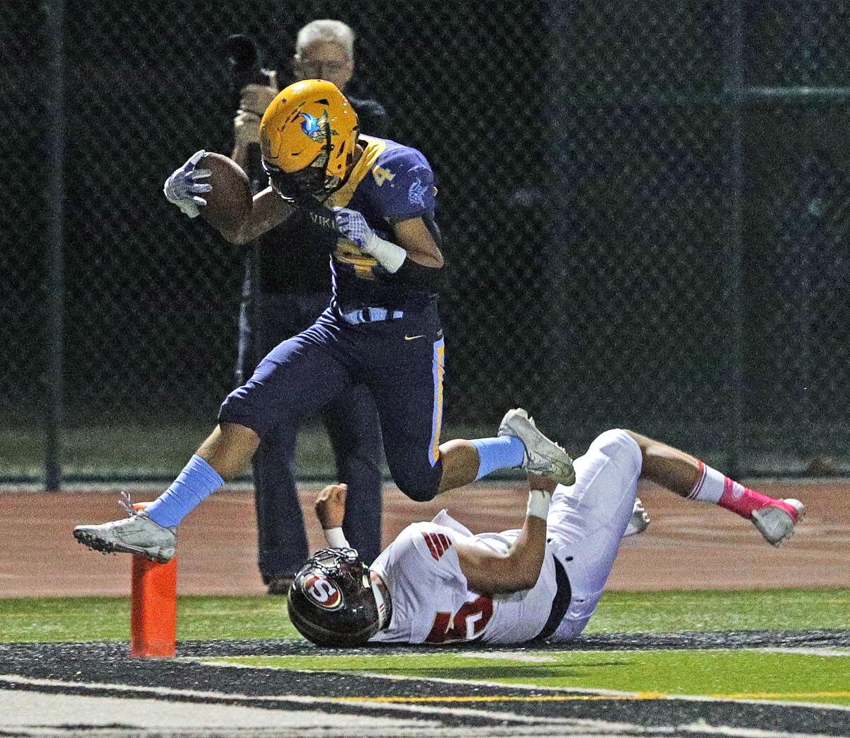 Marina's Pharoah Rush jumps over Segerstrom's Saul Ramirez and finds the end zone on a 20-yard run in the Big 4 League game at Westminster High on Friday.