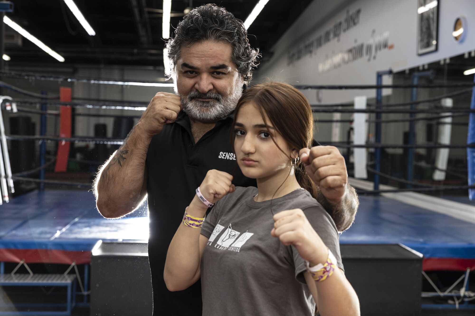 Fariborz Azhakh and his daughter, Laila pose with their fists up.