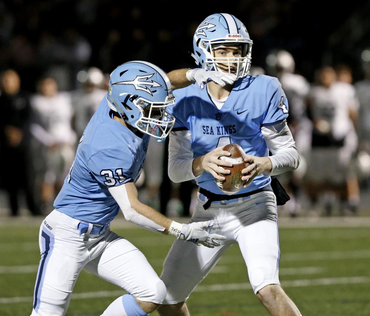 Corona del Mar's Ethan Garbers, right, fakes the handoff to Riley Binnquist in the CIF State Southern California Regional Division 1-A Bowl Game against Oceanside on Dec. 7 at Newport Harbor High.