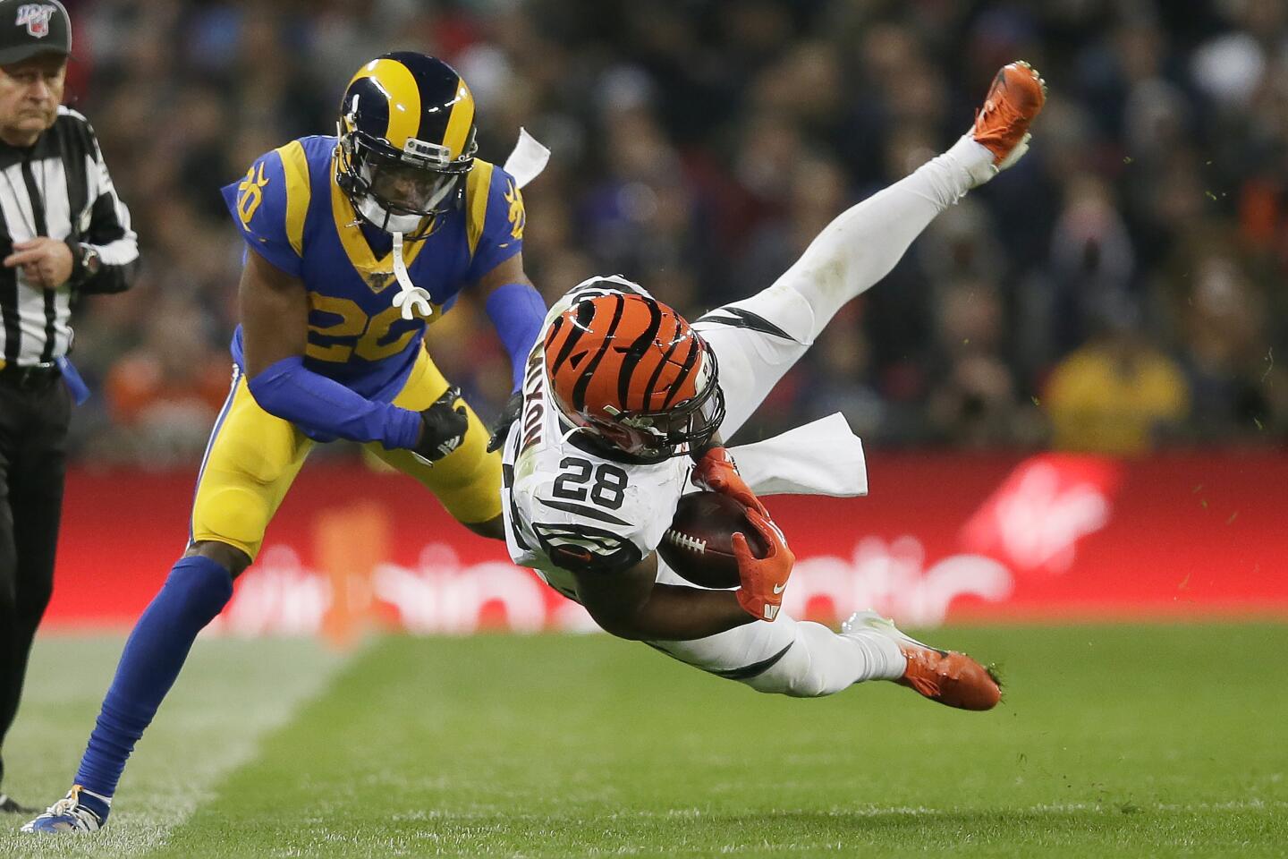 Bengals running back Joe Mixon (28) is brought down by Rams cornerback Troy Hill during the second half.