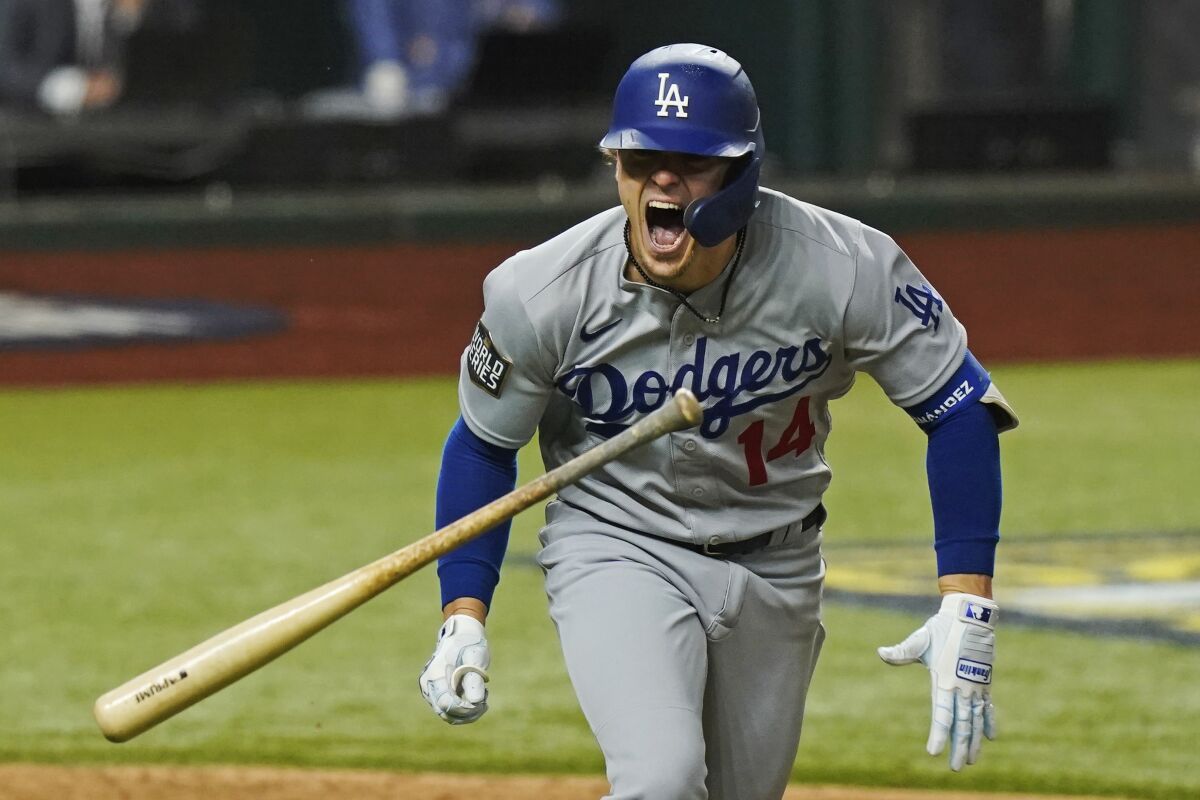 Dodgers' Kiké Hernández slings his bat as he celebrates an RBI-double.