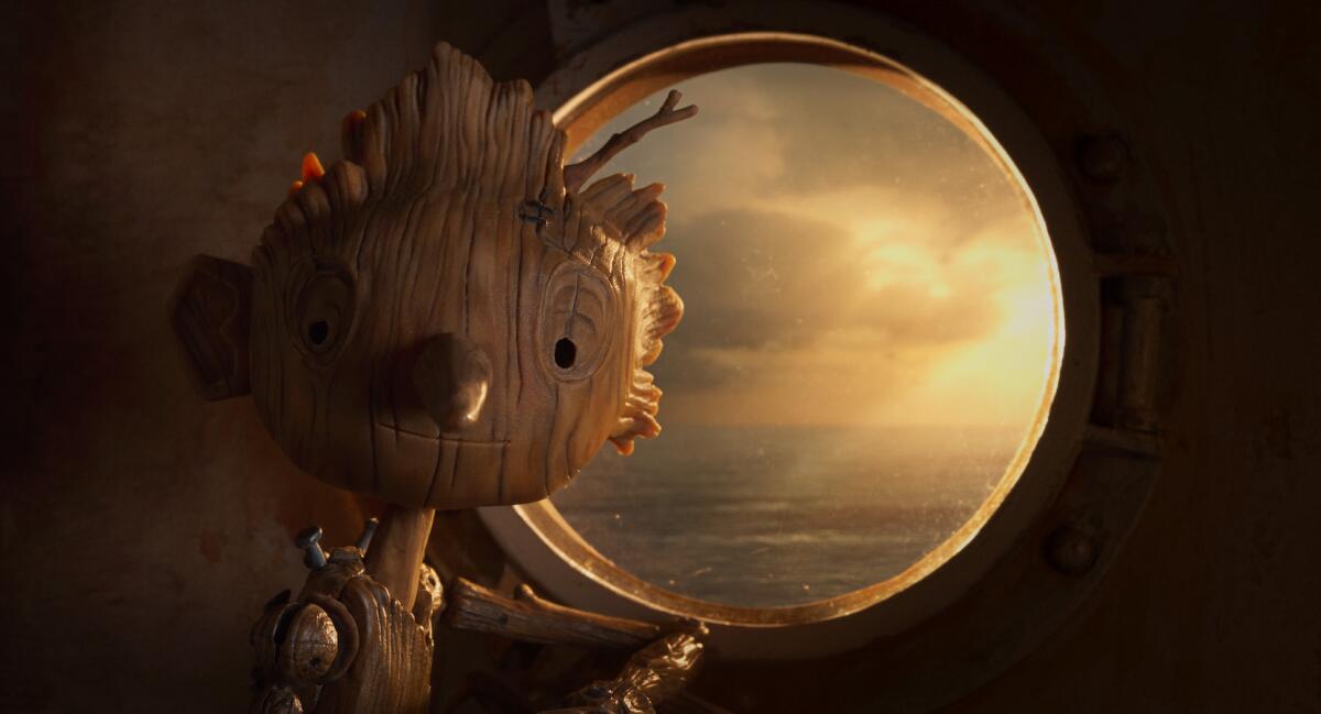 A wooden boy in front of portal displaying water in the animated movie "Guillermo del Toro's Pinocchio."