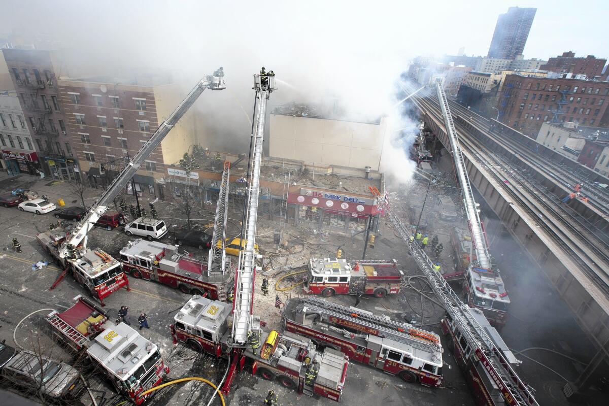 Firefighters battle a blaze in a collapsed building in East Harlem. A resident of one of the two destroyed buildings said neighbors had reported an overpowering smell of gas to fire officials a day earlier.