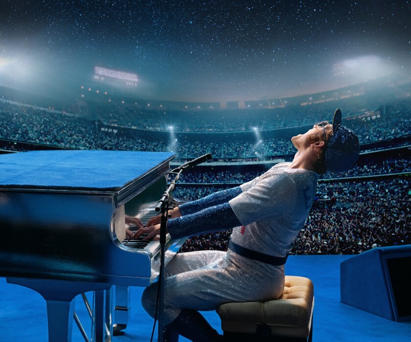 Actor Taron Egerton sits at the piano, with his head tilted back as he recreates Elton John's 1975 Dodger Stadium moment.