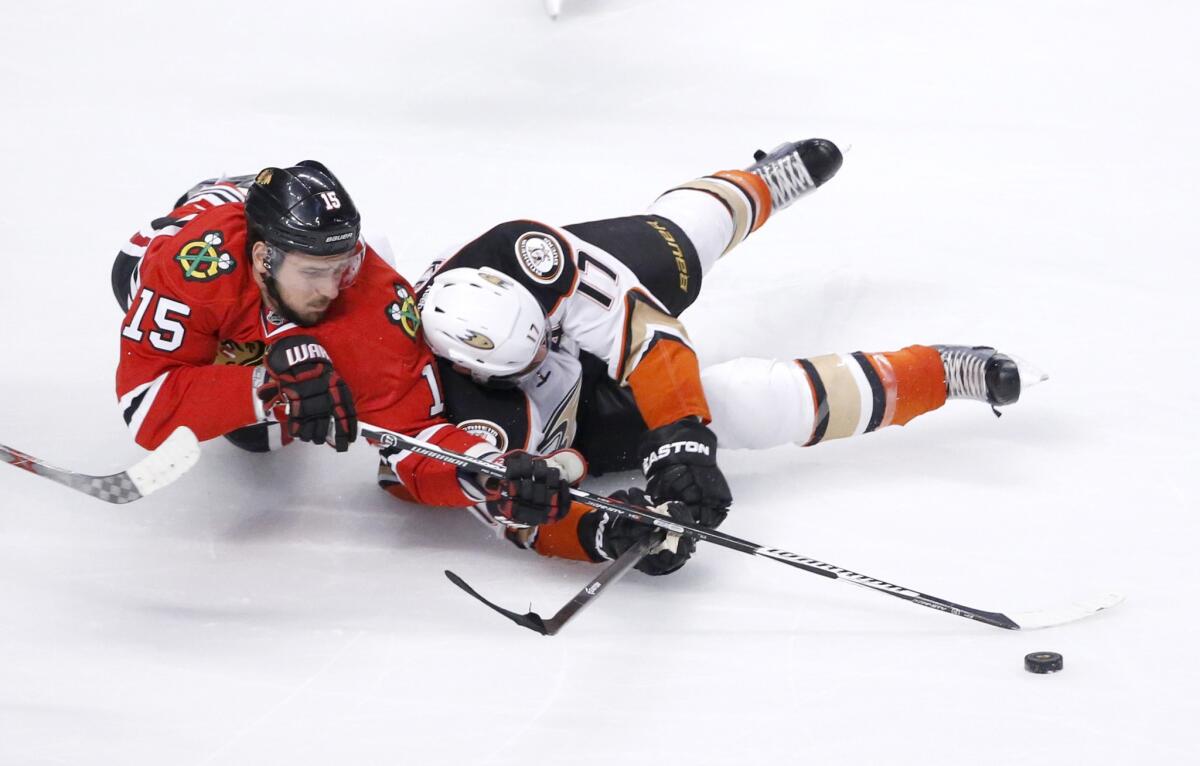 Blackhawks center Artem Anisimov and Ducks center Ryan Kesler, right, battle for a loose puck during the first period.