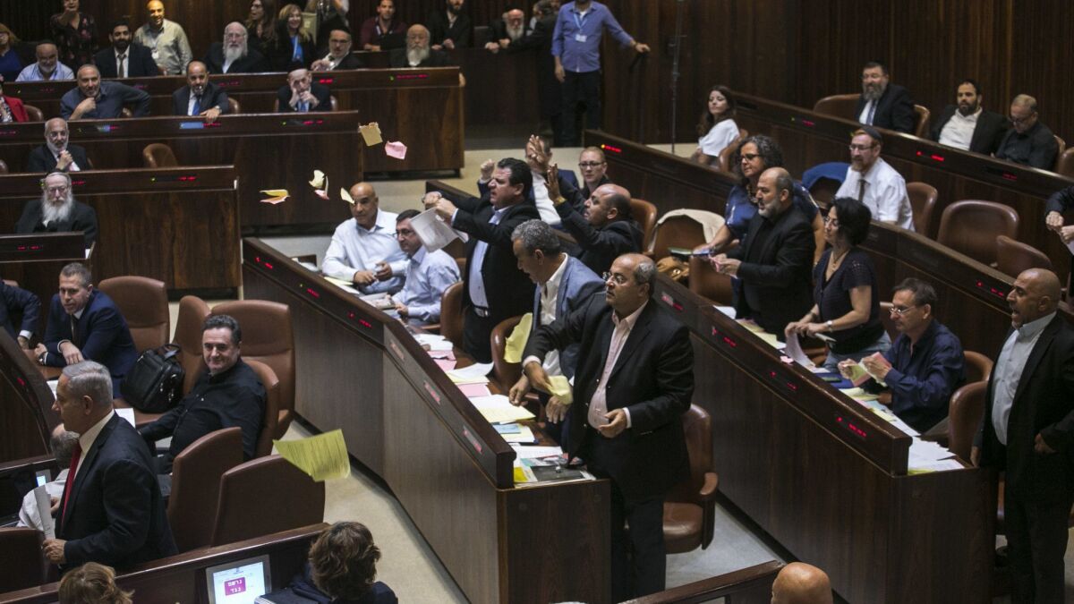 Arab lawmakers stand up in protest during a Knesset session in Jerusalem on July 19.
