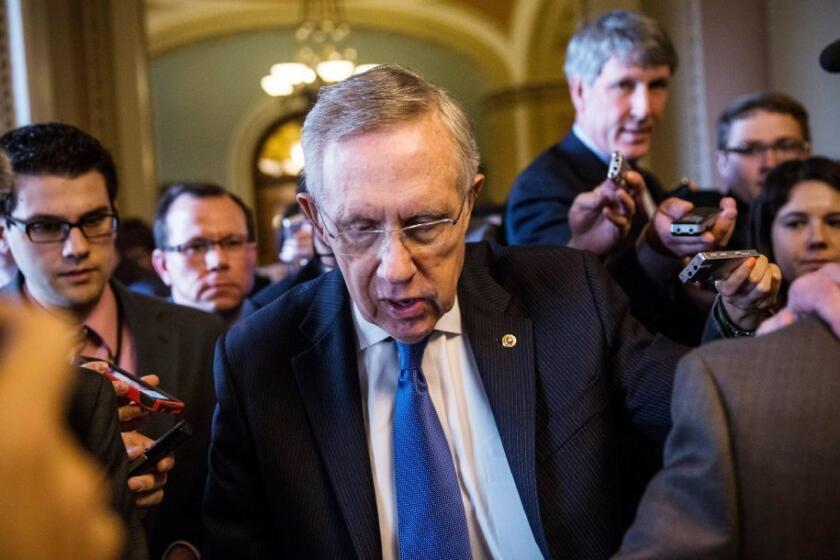 Surrounded by reporters, Majority Leader Harry Reid walks through the halls of Senate.