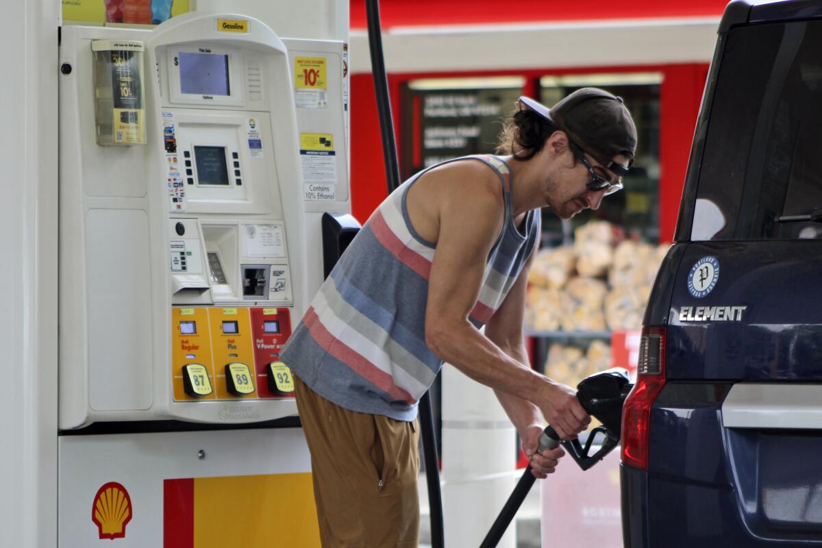 ARCHIVO - Patrick Coffin, residente en Oregón, llena el tanque de su coche en una gasolinera 