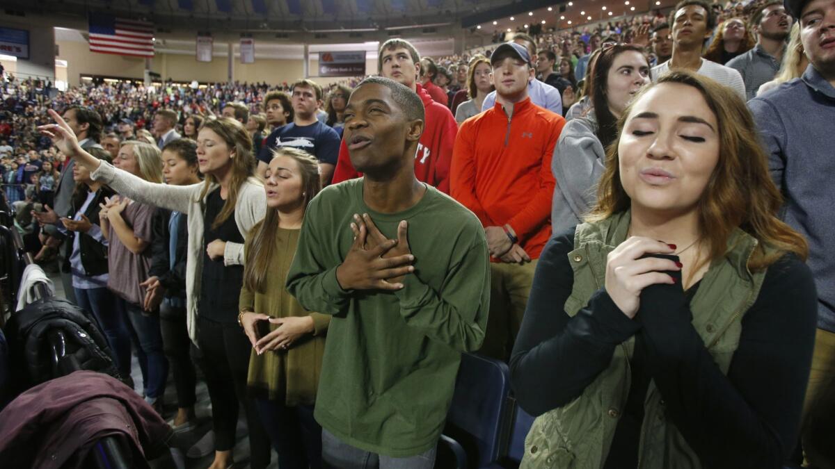 Liberty University students sing and pray prior to a speech by then-Republican vice presidential candidate, Indiana Gov. Mike Pence on Oct. 12, 2016.