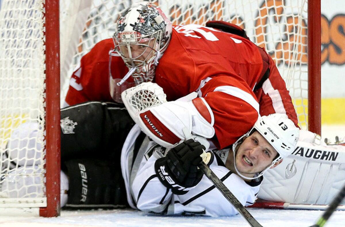 Kings forward Kyle Clifford slides into the crease underneath Red Wings goalie Jimmy Howard during play in the second period Saturday. Howard proceeded to pummel Clifford, igniting a skirmish.