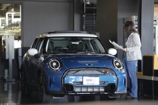 A potential buyer looks over a 2023 Cooper S sedan on the floor of a Mini dealership Friday, Feb. 17, 2023, in Highlands Ranch, Colo. Over the past year, the Fed has raised its key short-term rate eight times, causing many kinds of consumer and business loans, including auto loans, to become more expensive. (AP Photo/David Zalubowski)