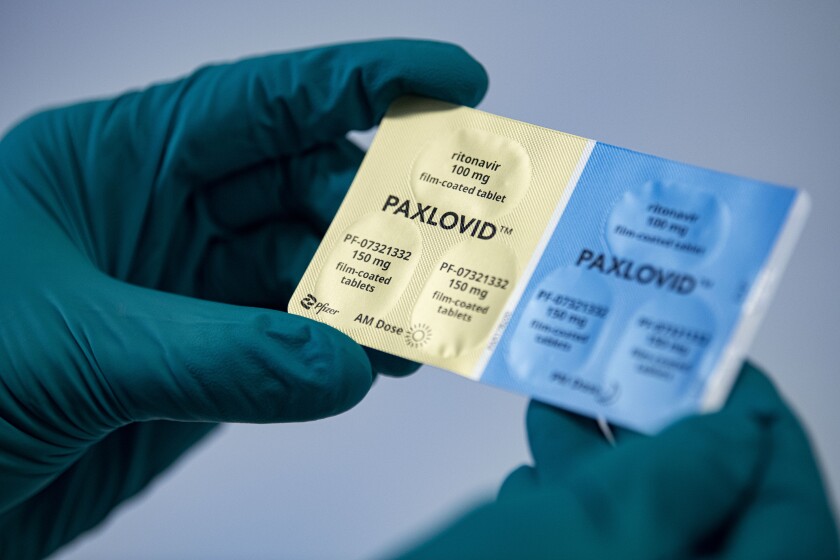 A person holds a package of the drug Paxlovid.
