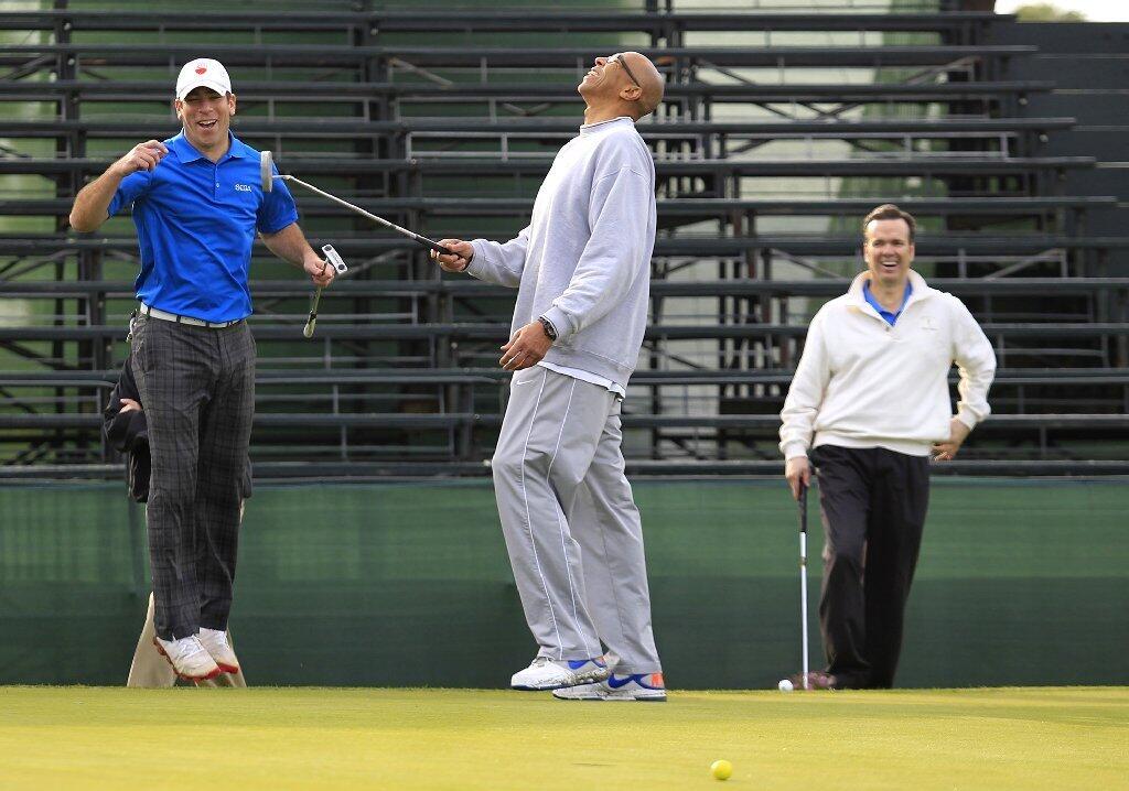 Sportscasters Mark Williard, left, Mychal Thompson, center, and John Ireland, right, share a laugh after Thompson missed a putt on Hole 18, as they wait for the start of the second annual Toshiba Classic Skills Challenge at Newport Beach Country Club on Tuesday.