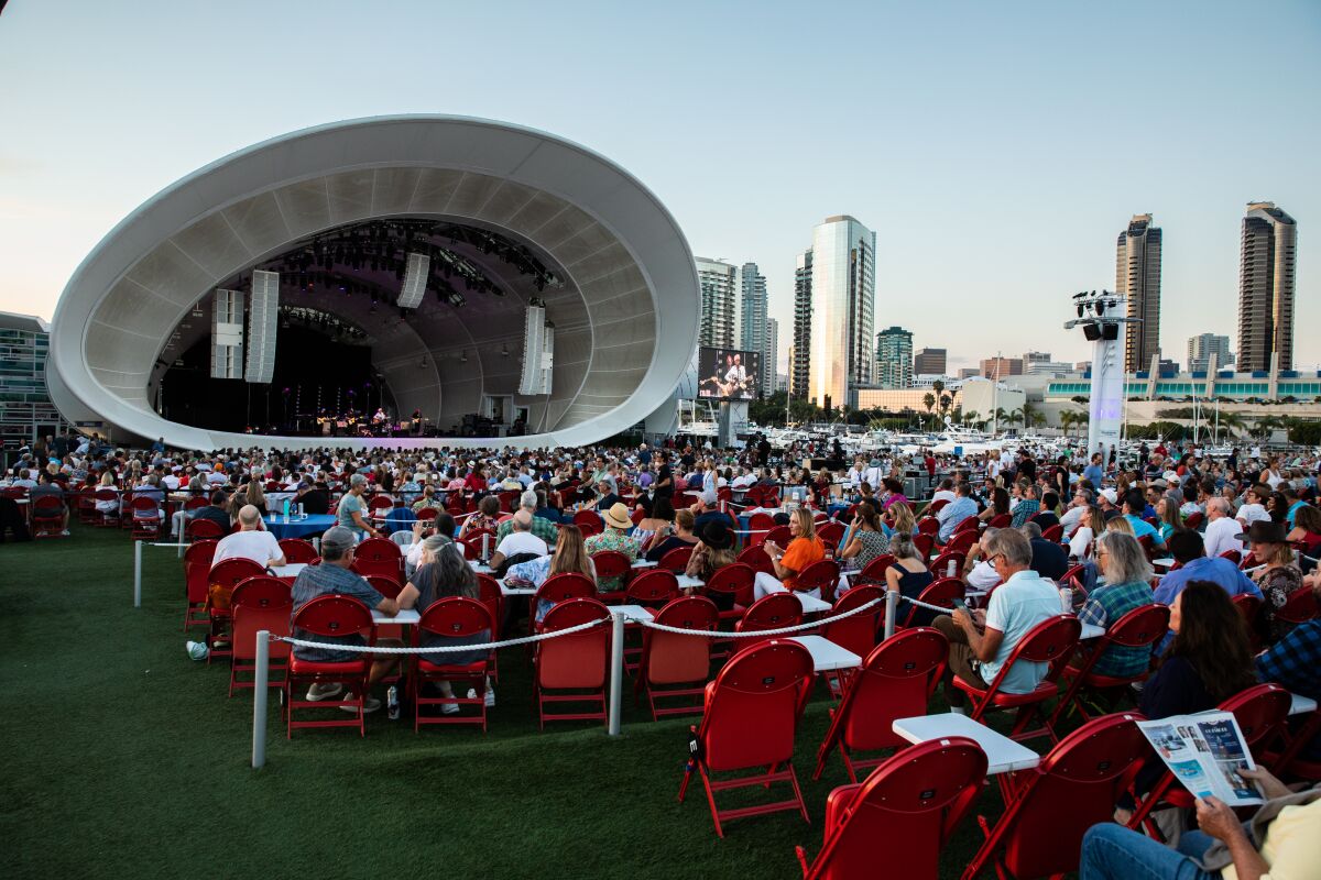 Attendees watch Nick Lowe & Los Straitjackets perform at The Rady Shell at Jacobs Park in San Diego.