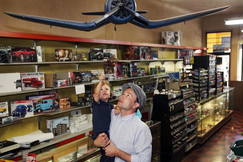 LOS ANGELES, CA-APRIL 22, 2019: Colby Gomez, left, 2, and his dad Tim Gomez, right, the great, great grandson and great grandson of Evetts Model Shops owner, interact with a model plane put together by the owner on April 22, 2019, in Los Angeles, California. With rent that has quadrupled since 2012 and the pressure of online competition, their business has become unaffordable and the 70-year-old Santa Monica icon is closing its doors April 24. (Photo By Dania Maxwell / Los Angeles Times)