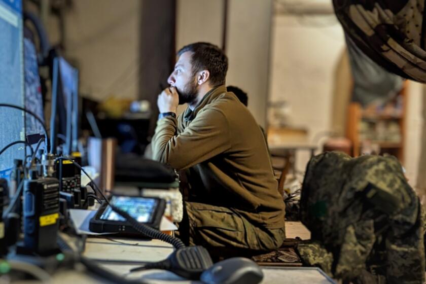 An intelligence commander watches a drone feed to identify targets and coordinate fire.