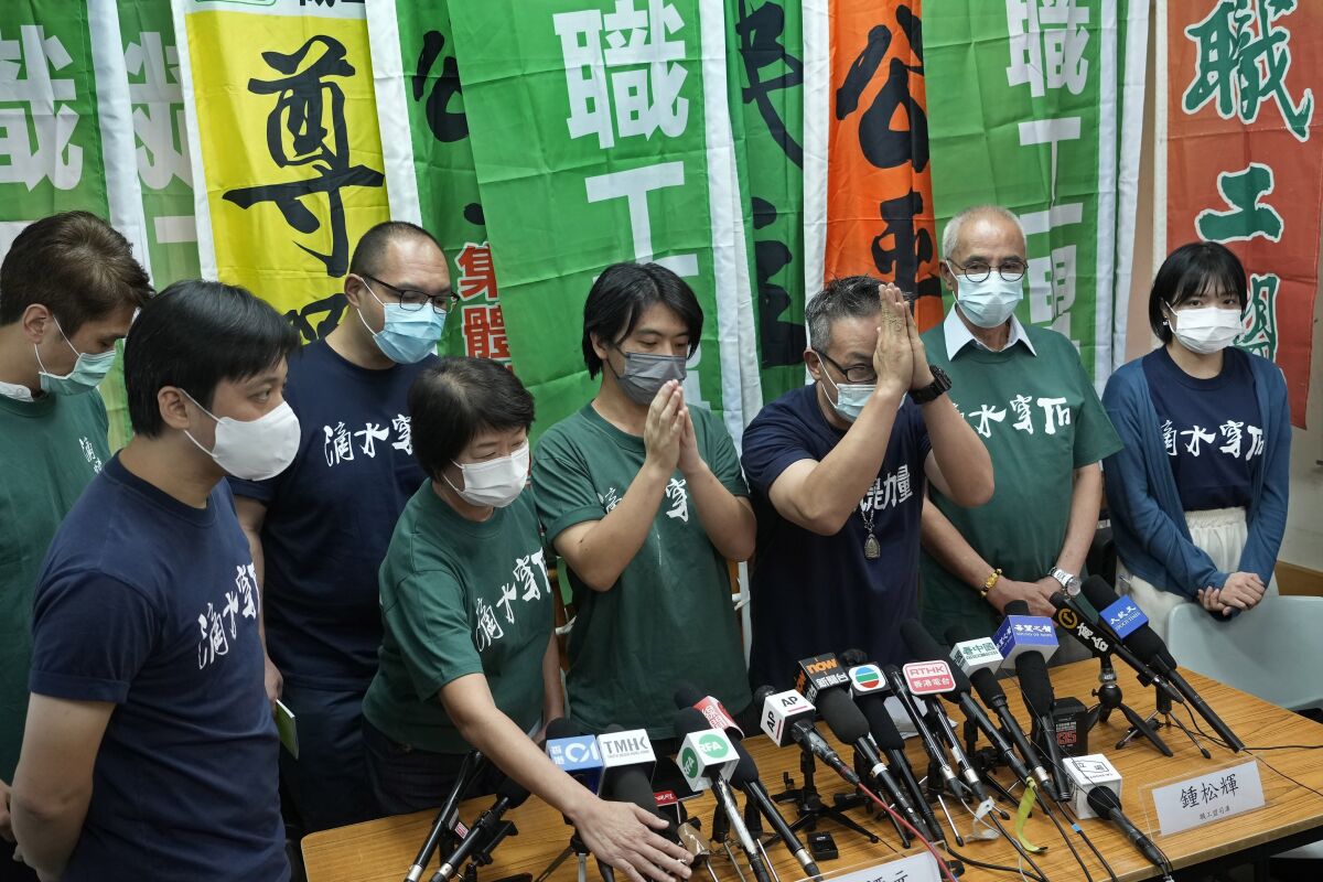 FILE - The vice-chairman of Hong Kong Confederation of Trade Unions, Leo Tang Kin-wah, fourth from right, with green T-shirt, attends a news conference in Hong Kong Sunday, Sept. 19, 2021. Hong Kong's national security police used a colonial-era sedition law to arrest six people Wednesday, April 6, 2022, on suspicion of causing a nuisance at court hearings in December and January. The suspects — four men and two women aged between 32 and 67 years old — were arrested on suspicion of committing an "act or acts with seditious intent," an offense under the Crimes Ordinance. (AP Photo/Vincent Yu, File)