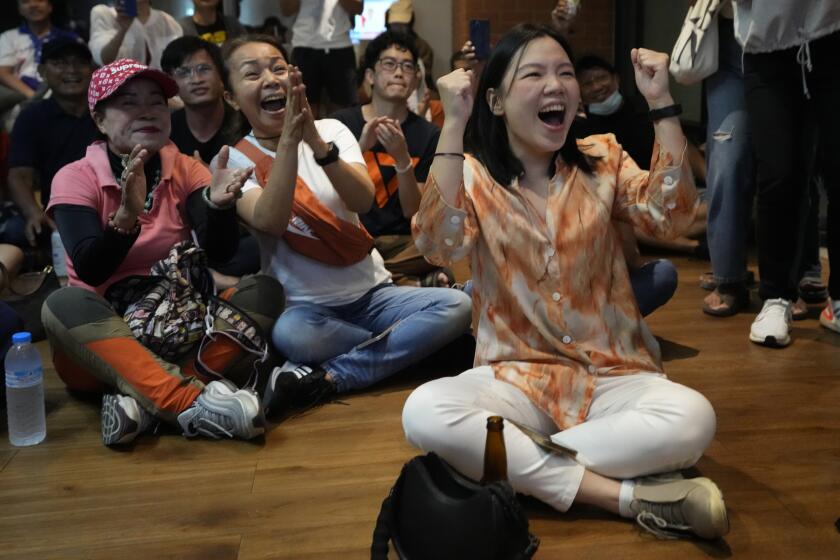 Supporters of Move Forward party cheer as they watch counting of votes on television at Move Forward Party headquarters in Bangkok, Thailand, Sunday, May 14, 2023. Vote counting was underway Sunday in Thailand's general election, touted as a pivotal chance for change nine years after incumbent Prime Minister Prayuth Chan-ocha first came to power in a 2014 coup. (AP Photo/Sakchai Lalit)