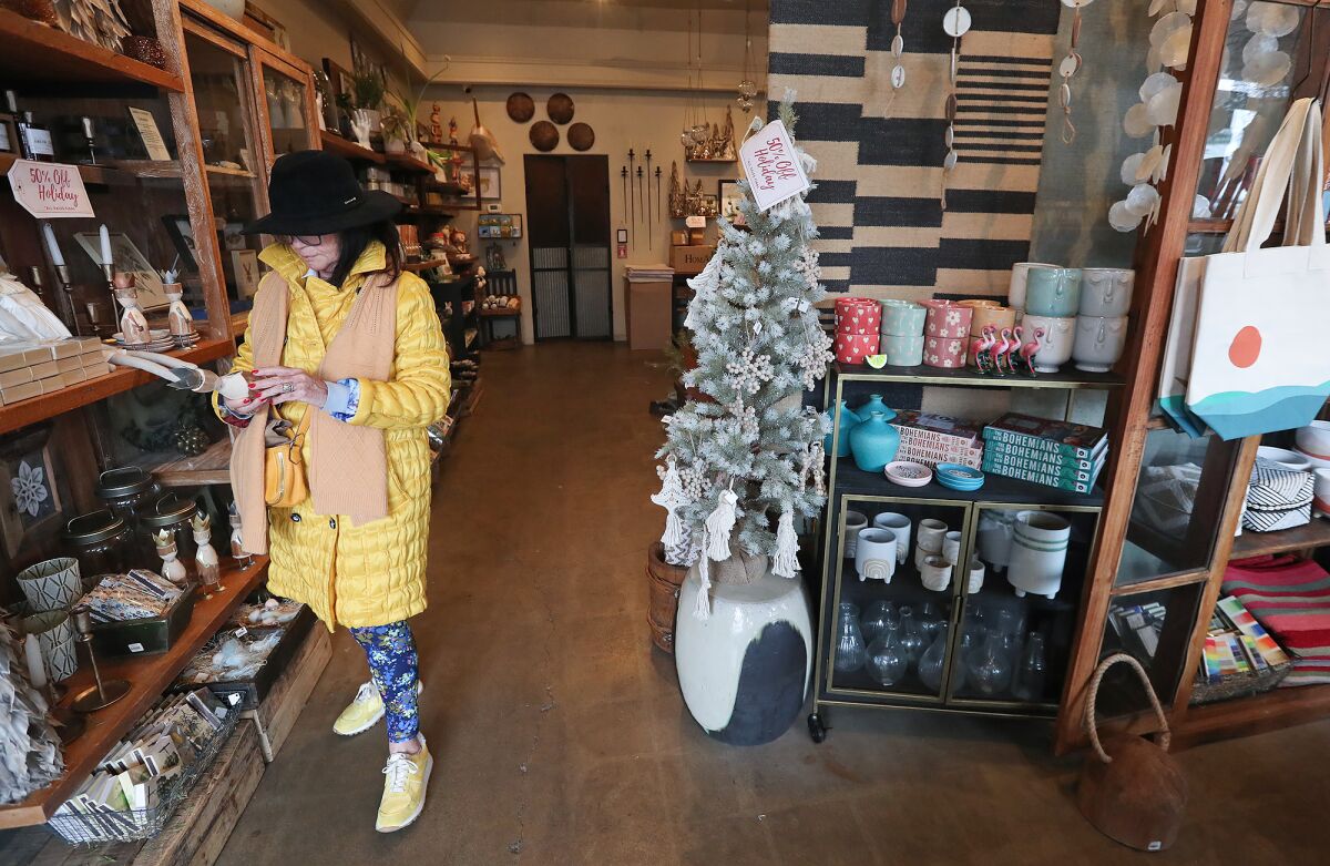 A woman shops at an AREO store in downtown Laguna Beach on Dec. 29.