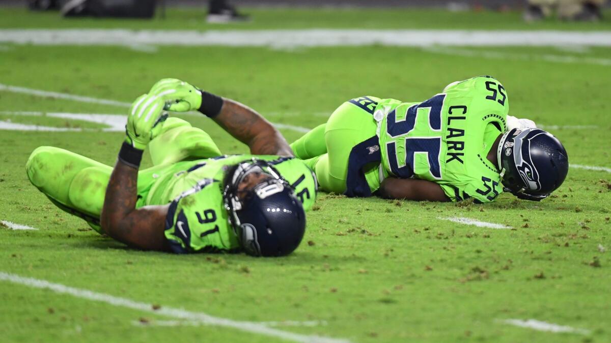 Defensive end Frank Clark and defensive tackle Sheldon Richardson of the Seattle Seahawks both lay on the field after a play.