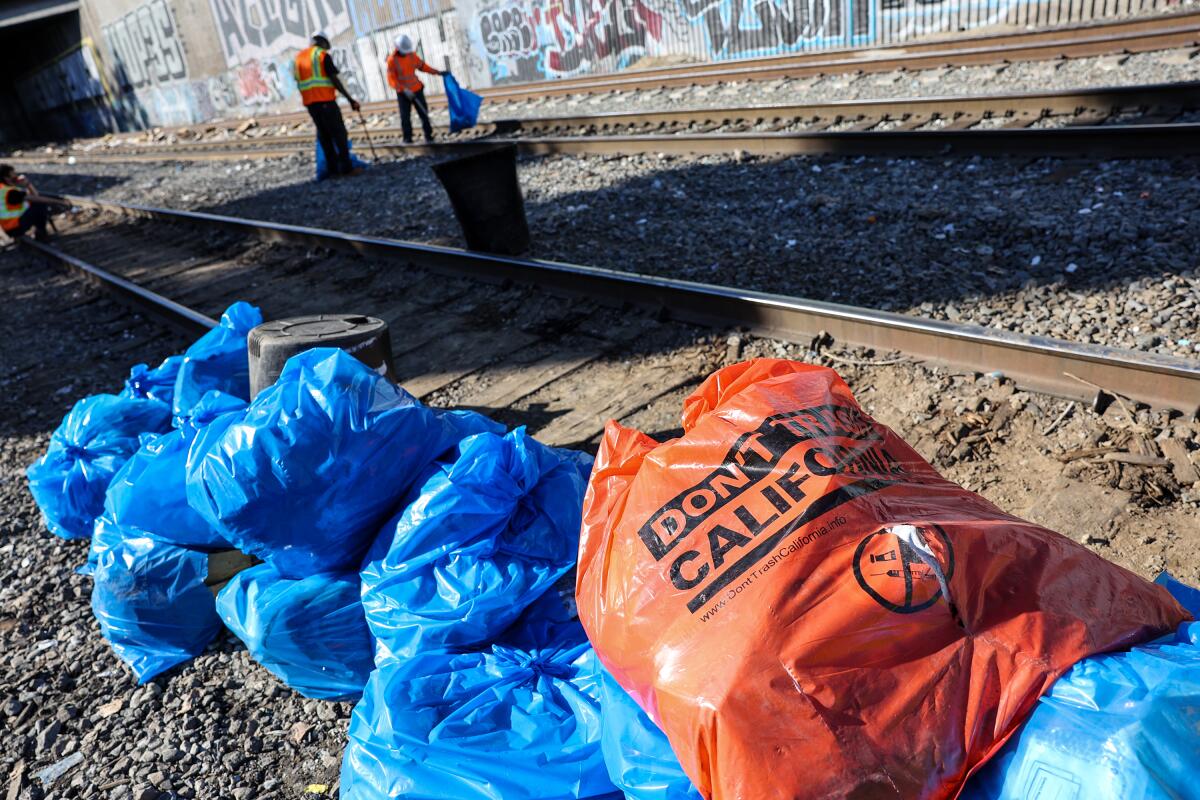 CalTrans crews clear debris from Union Pacific train tracks where cargo cars were looted.