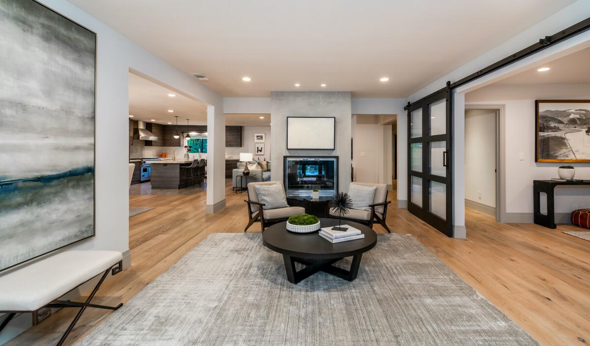 Sitting area with furniture, a rug and abstract wall art.