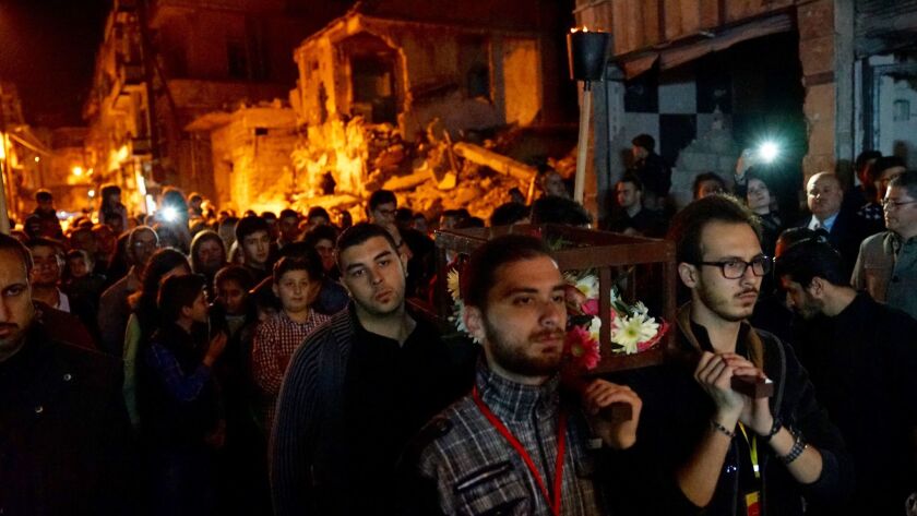 Hundreds of people celebrate Good Friday in Homs with a procession at night through the damaged neighborhood of Bustan Al Dewan.