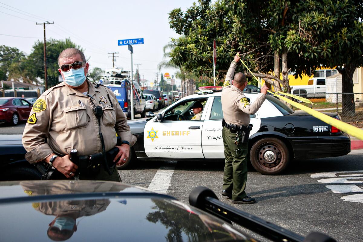 Los Angeles County sheriff's deputies block Carlin Avenue as they search for a carjacking suspect.