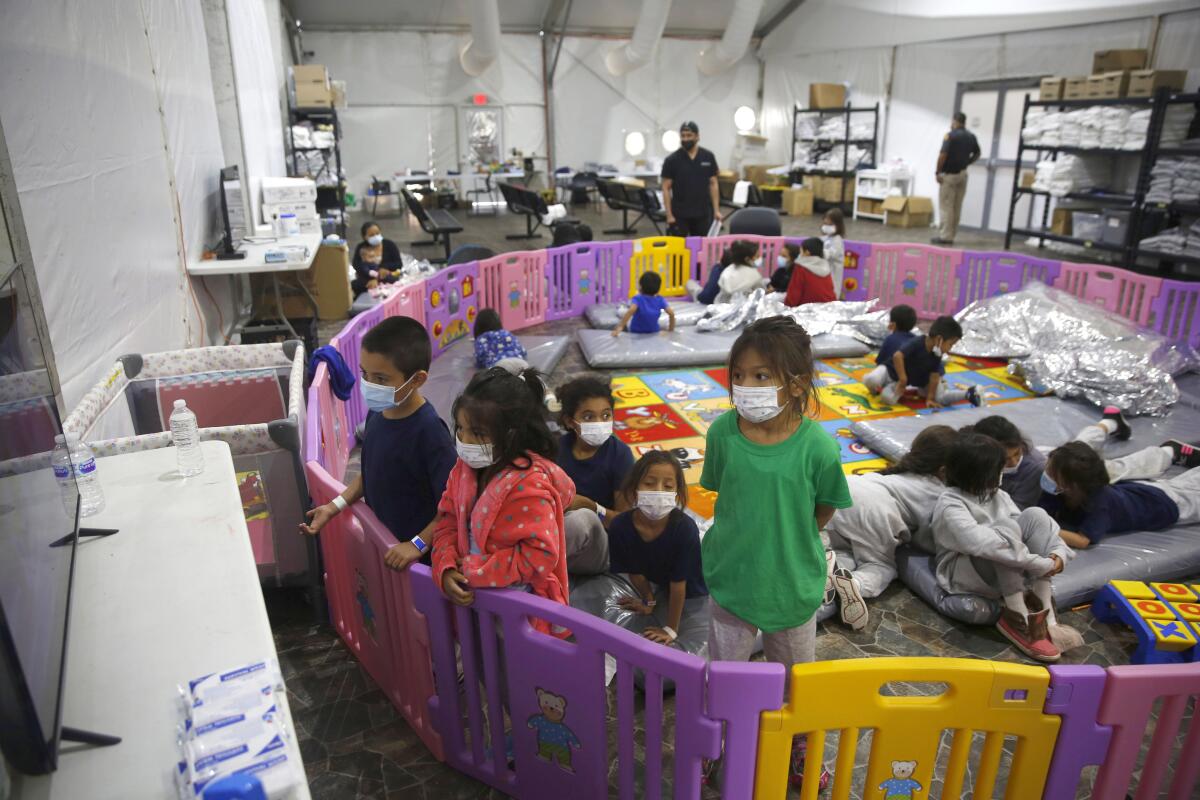 Children watch television inside a playpen at the U.S. Customs and Border Protection facility.