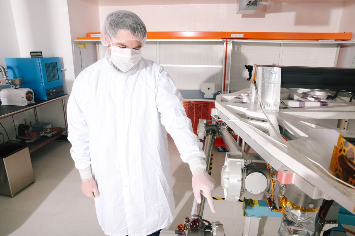 JPL'nin COLDArm baş araştırmacısı Ryan McCormick, robotik kolun bir prototipinin yanında duruyor.