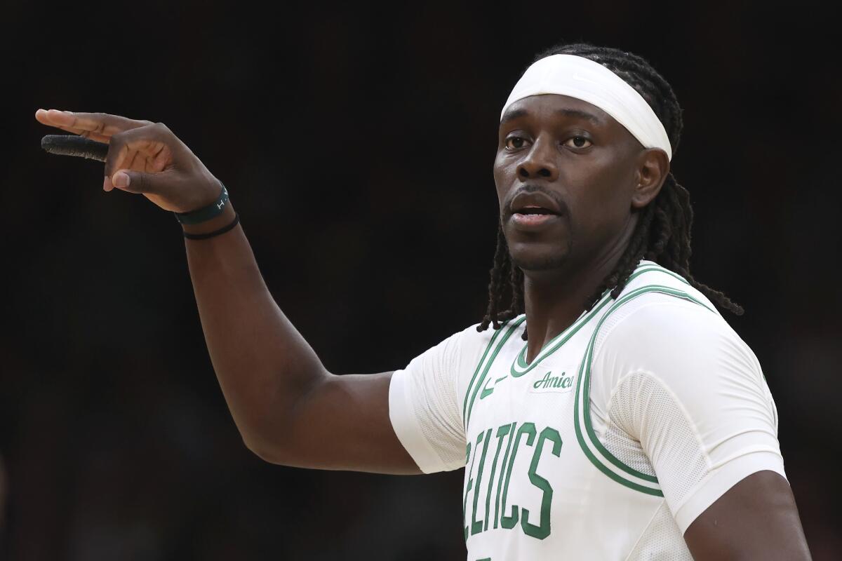 Celtics guard Jrue Holiday points with his right hand.
