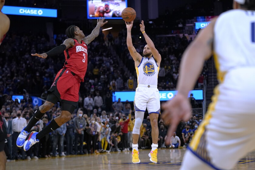 Golden State Warriors guard Stephen Curry (30) shoots the game-winning basket against Houston Rockets guard Kevin Porter Jr. (3) at the end of an NBA basketball game in San Francisco, Friday, Jan. 21, 2022. (AP Photo/Jeff Chiu)