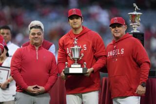 Los Angeles Angels' Shohei Ohtani, center, poses with general manger Perry Minasian.