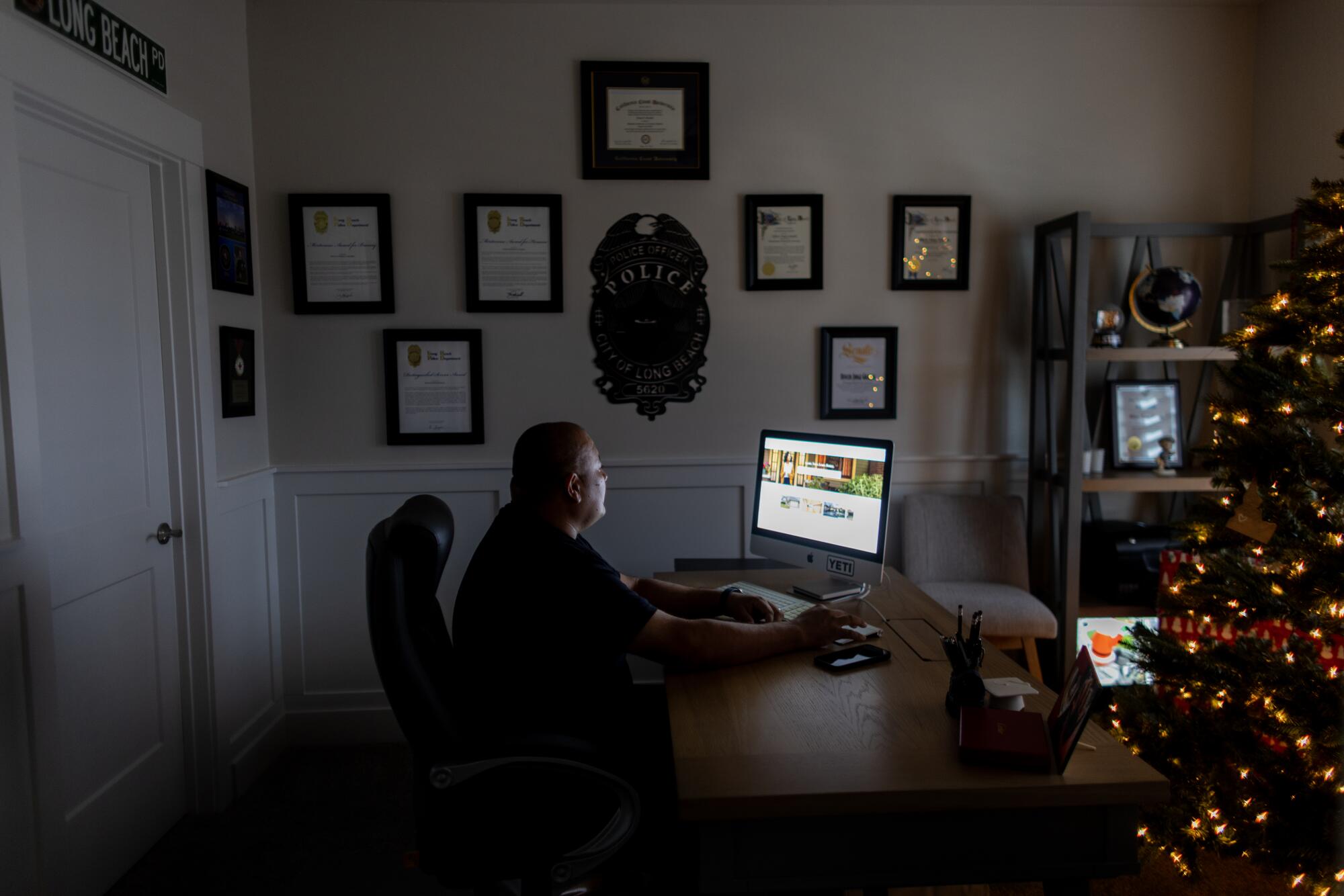 Jorge Grajeda, a retired Long Beach police officer, in his home office.