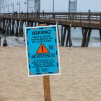 A sign warning visitors of possible water contamination near the Imperial Beach Pier.