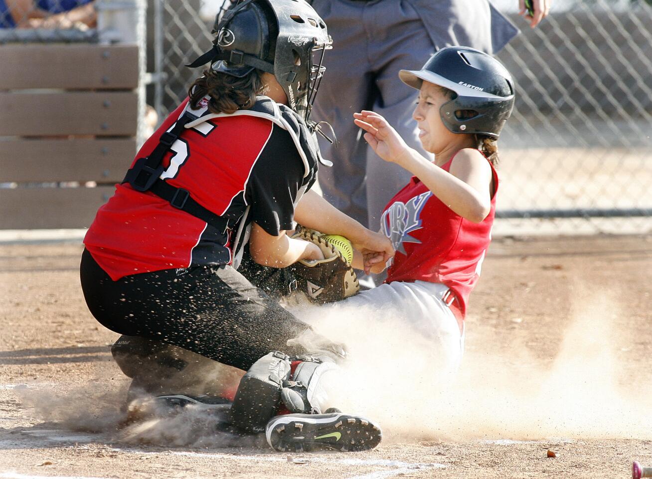 Tujunga Fury's Samantha Contreras, right, is tagged out at home by Glendale Firebelles' catcher Lacie Fradet in a Tri-Cities Junior softball game at Scholl Canyon Ball Fields in Glendale.