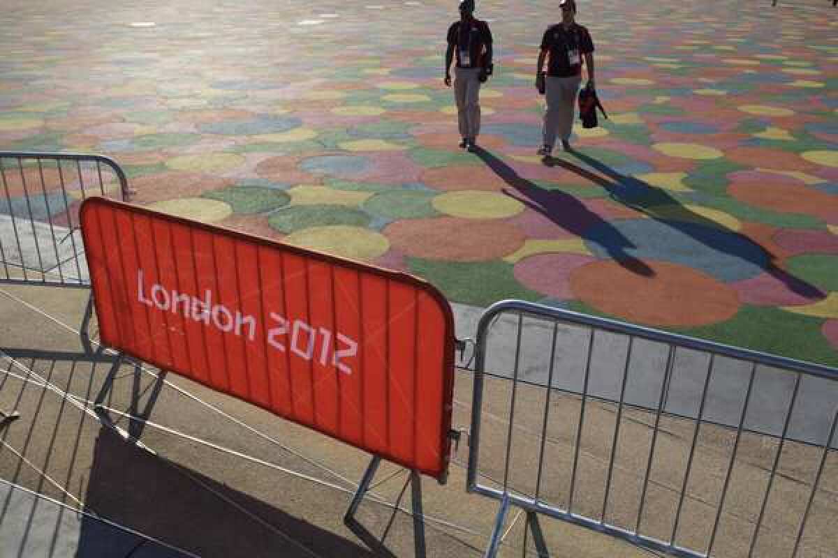 Volunteers for the London 2012 Olympics stroll across Olympic Park on Thursday, a day before the Games open.