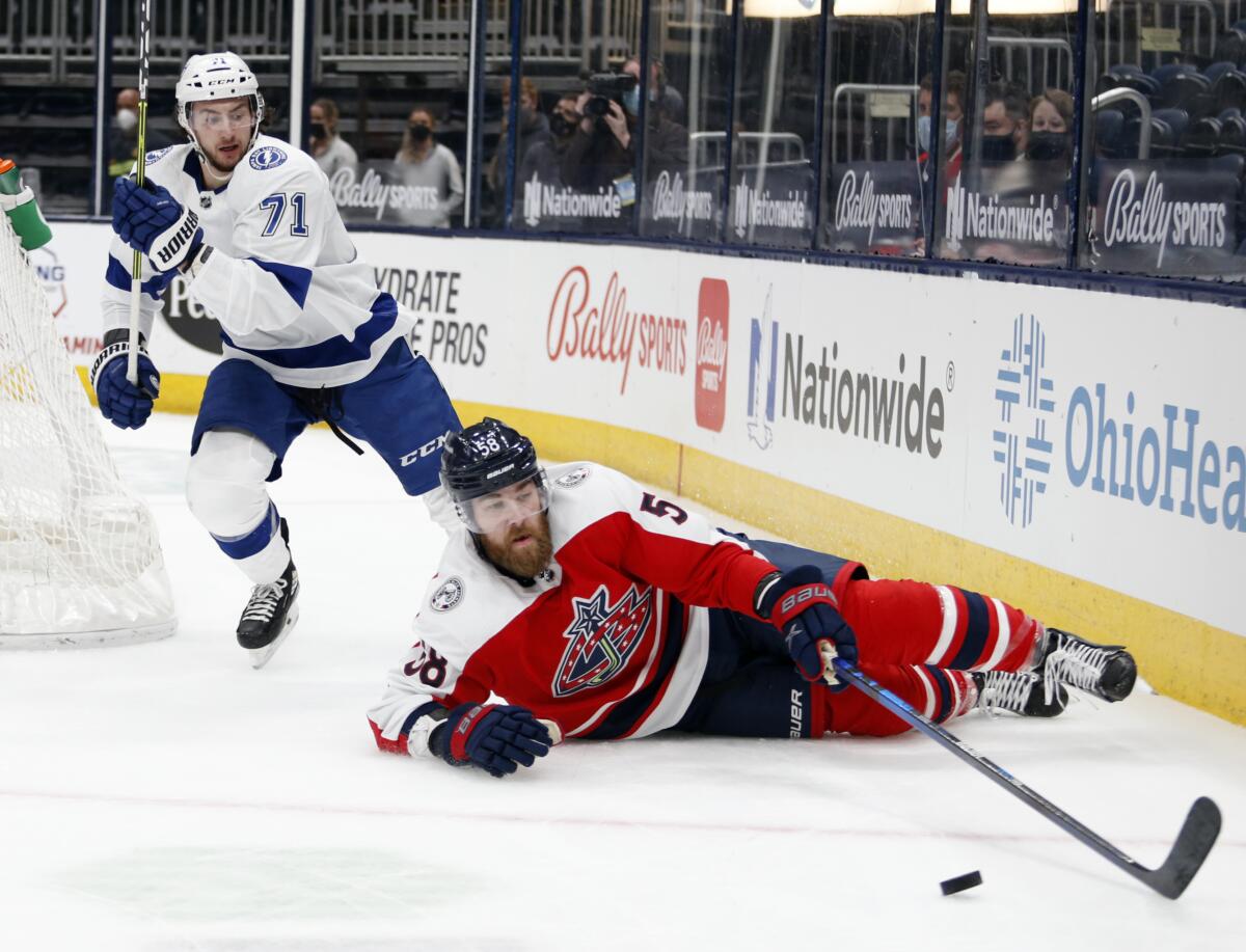 Columbus Blue Jackets defenseman David Savard, right, reaches for the puck in front of Tampa Bay Lightning forward Anthony Cirelli during the first period of an NHL hockey game in Columbus, Ohio, Tuesday, April 6, 2021. (AP Photo/Paul Vernon)