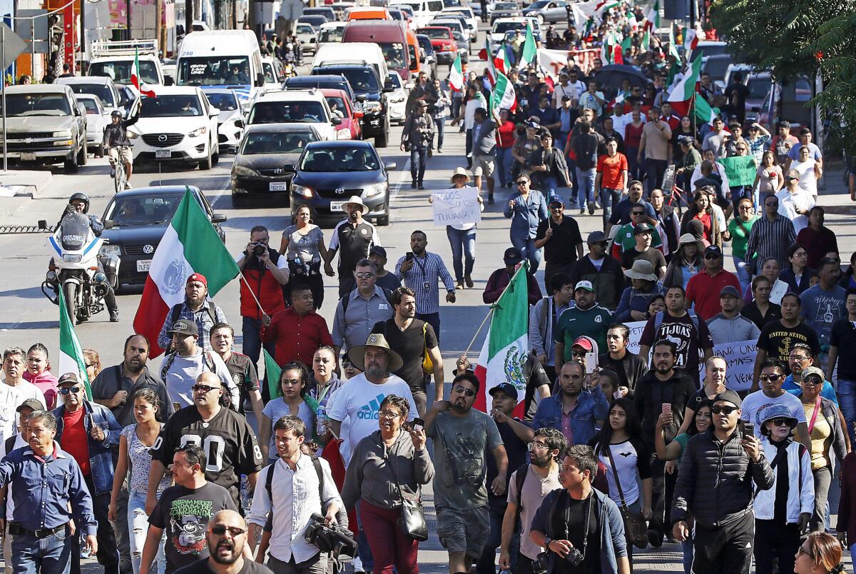 Hundreds of protesters march through downtown Tijuana, calling for a stop to the Central American migrant caravans passing through Mexico.