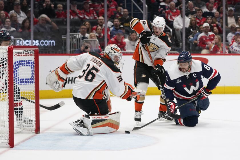 Washington Capitals left wing Alex Ovechkin, right, attempts but is unable to score a goal past Anaheim Ducks goaltender John Gibson, left, and defenseman Dmitry Kulikov in the third period of an NHL hockey game, Thursday, Feb. 23, 2023, in Washington. Anaheim won 4-2. (AP Photo/Patrick Semansky)