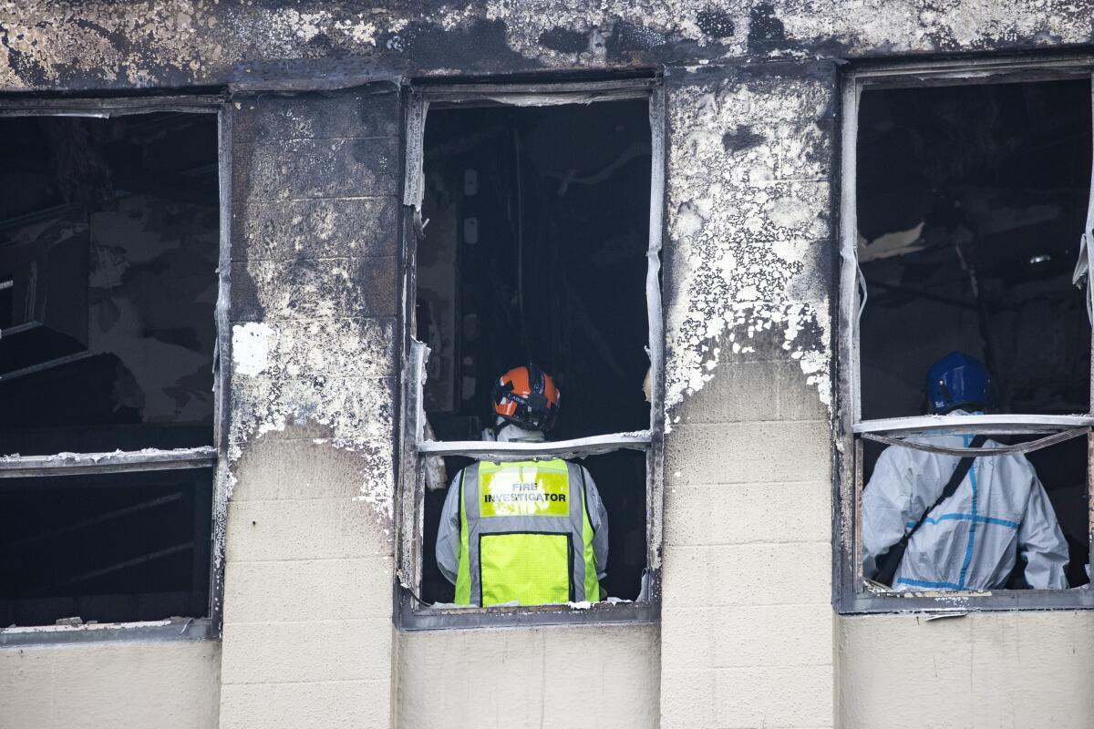 Investigators inside fire-damaged hostel