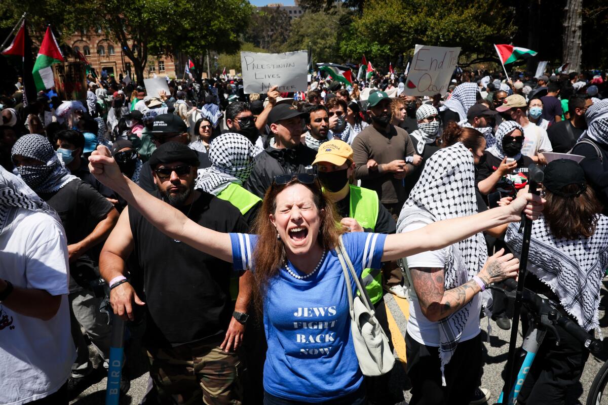 A woman with outstretched arms wears a T-shirt reading "Jews Fight Back Now."