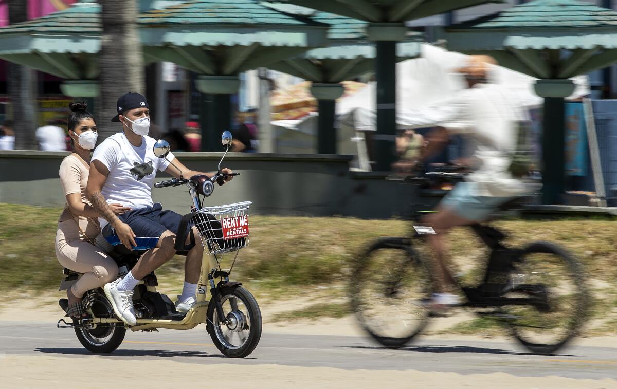 Masked and mobile, cyclists make their way along the bicycle path in Venice Beach. 