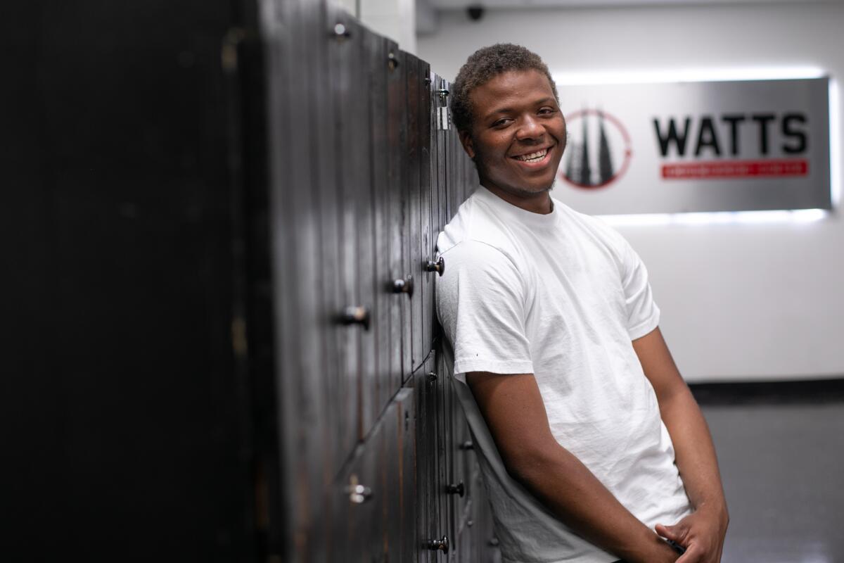 A man poses for a photo while leaning against a row of storage lockers