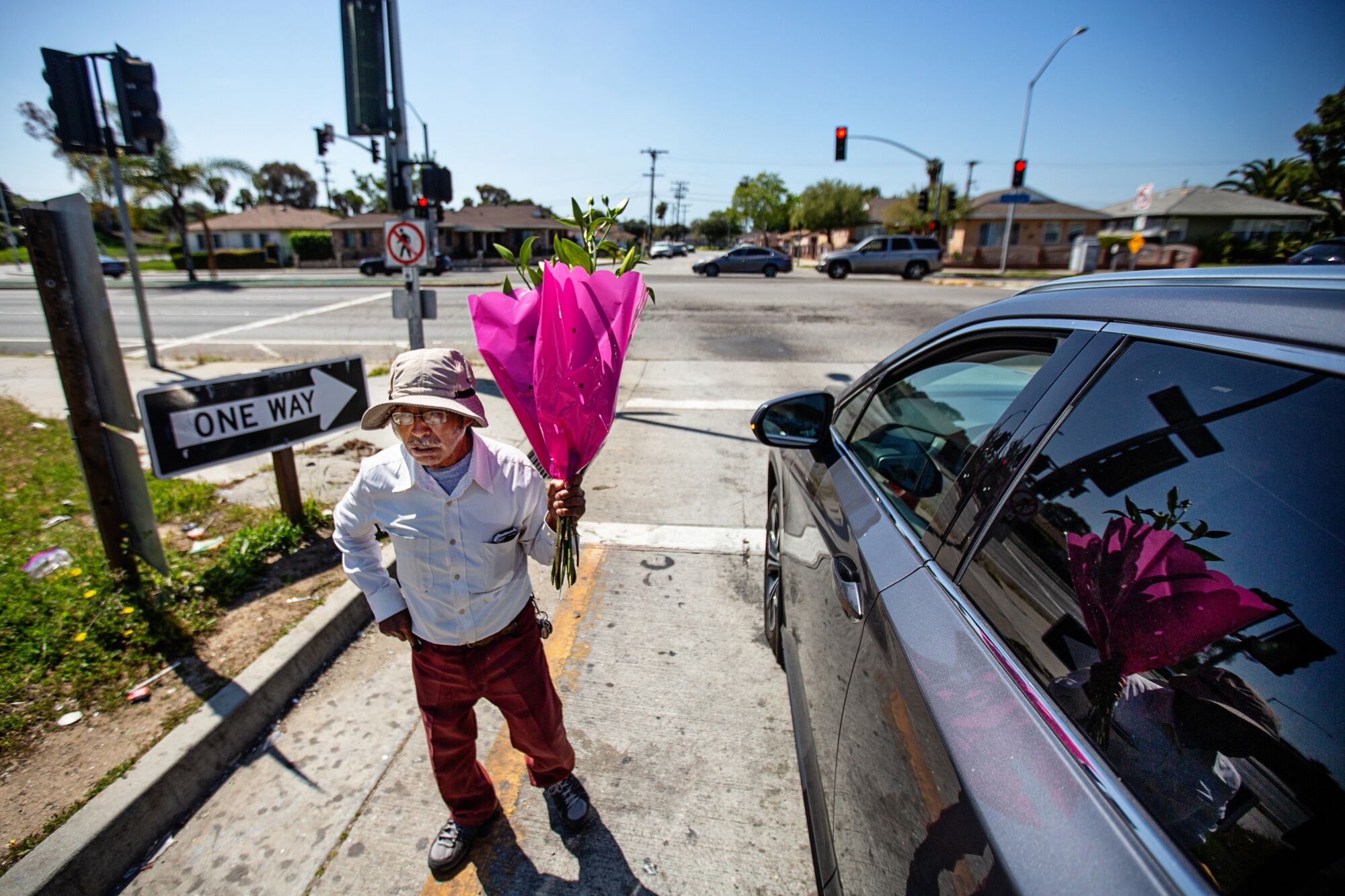 An Angeleno sells flowers on a 105 Freeway offramp in Inglewood. 