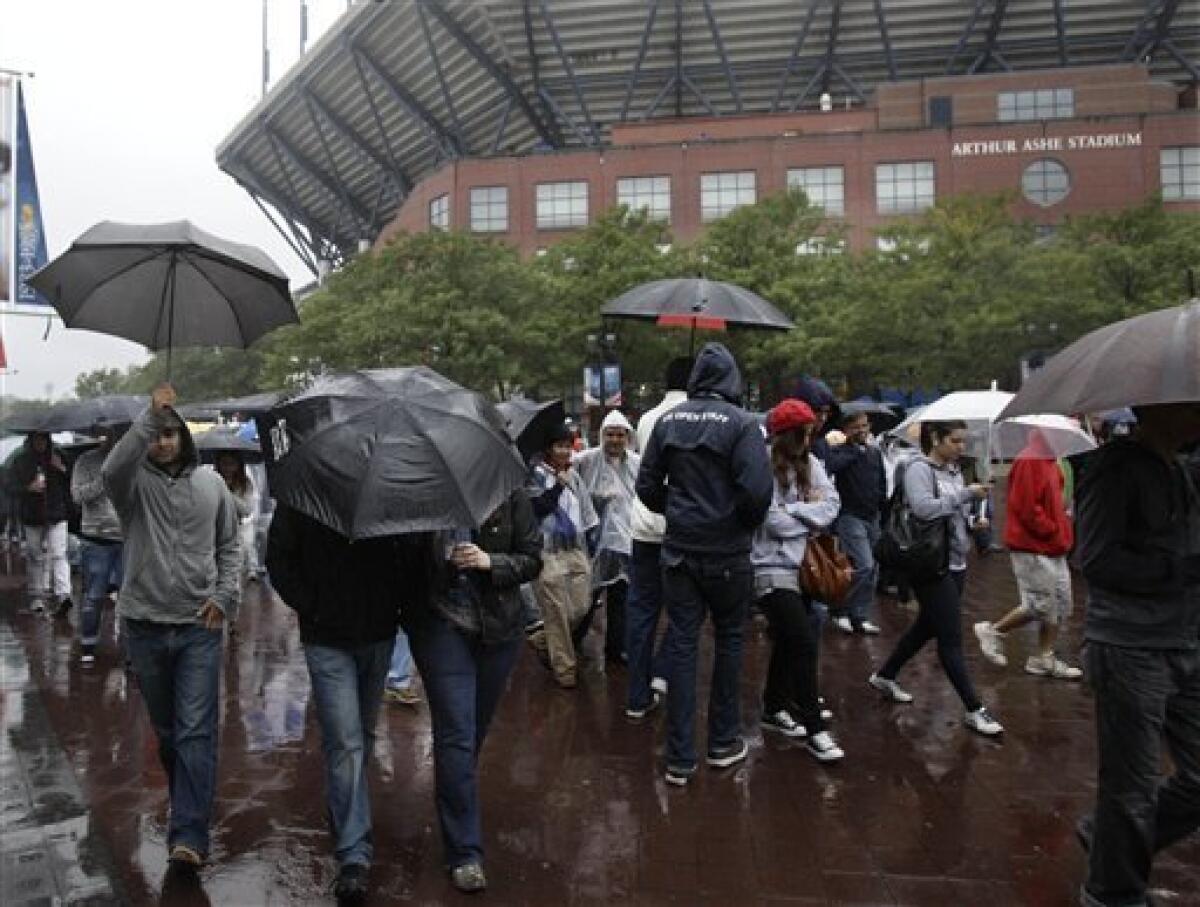 A fan walks in the stands as rain canceled the start of the