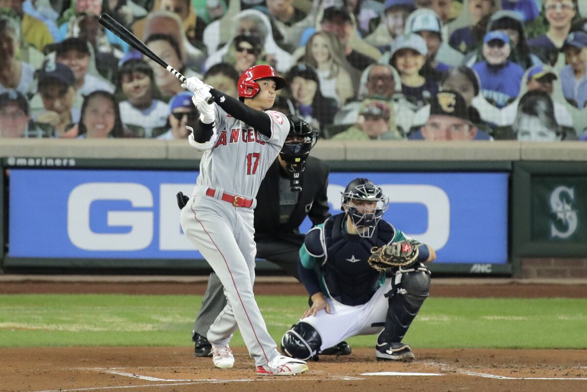 Los Angeles Angels' Shohei Ohtani (17) watches his solo home run as Seattle Mariners catcher Joe Hudson, right, looks on during the second inning of a baseball game Thursday, Aug. 6, 2020, in Seattle. (AP Photo/Ted S. Warren)