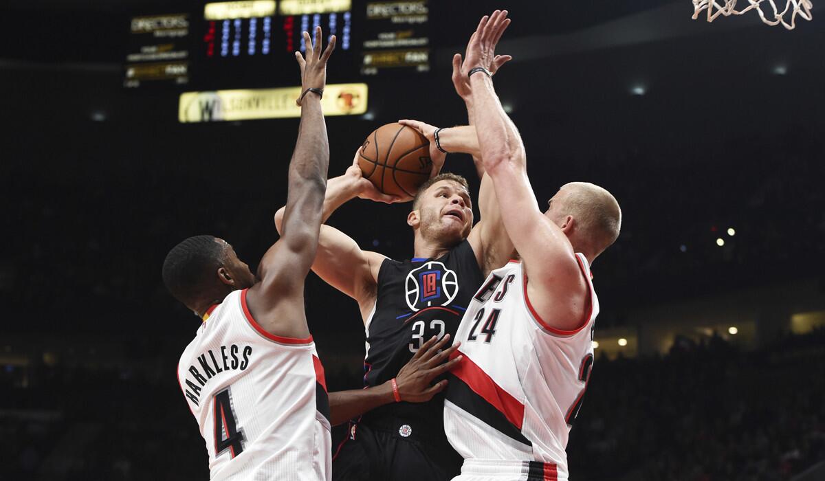Clippers forward Blake Griffin (32) drives to the basket against Portland Trail Blazers forward Maurice Harkless (4) and forward Mason Plumlee (24) during the first quarter Thursday.